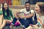 PISA Foreign Language - teenage students sitting on the ground laughing